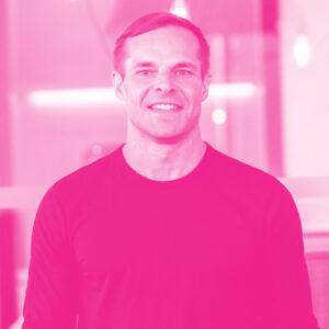 Mark Shulgan's headshot with a hot pink filter.